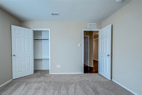 an empty room with closet and wooden floor