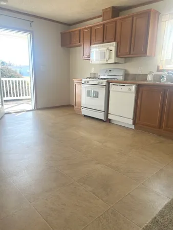 a kitchen with stainless steel appliances granite countertop a stove a sink and a white cabinets