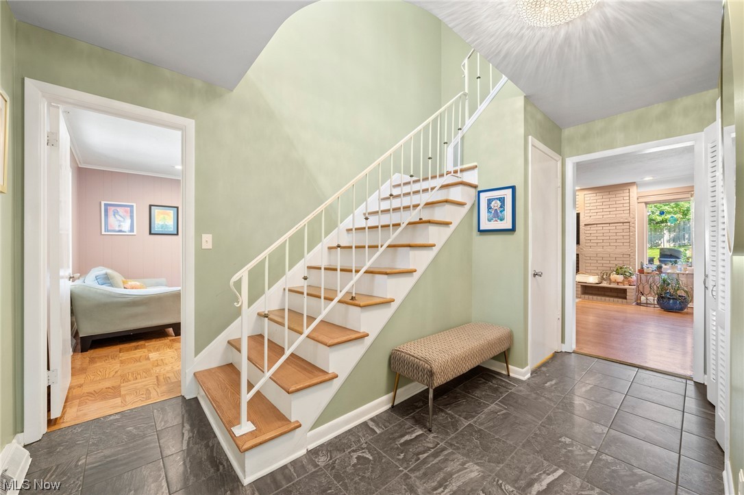 2685 Green Road Shaker Heights, OH 44122 - Photo 4 of 31 Stairs with brick wall, light hardwood floors, and ornamental molding