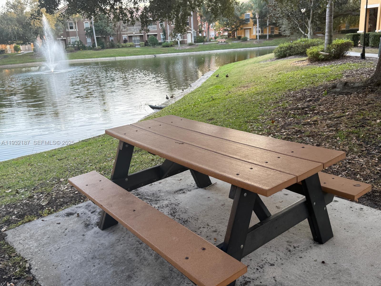 19914 Villa Creek Drive, Unit 202 Orlando, FL 32821 - Photo 16 of 19 a view of a wooden bench next to a lake