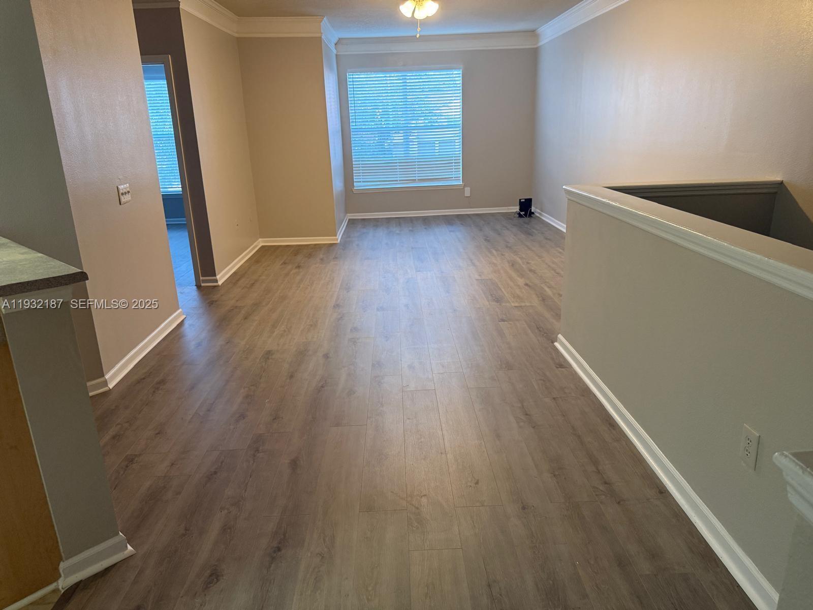 19914 Villa Creek Drive, Unit 202 Orlando, FL 32821 - Photo 3 of 19 wooden floor in an empty room with a window