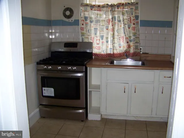 a stove top oven sitting inside of a kitchen