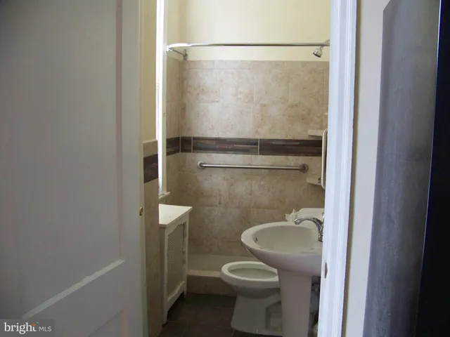 a bathroom with a granite countertop toilet and a shower