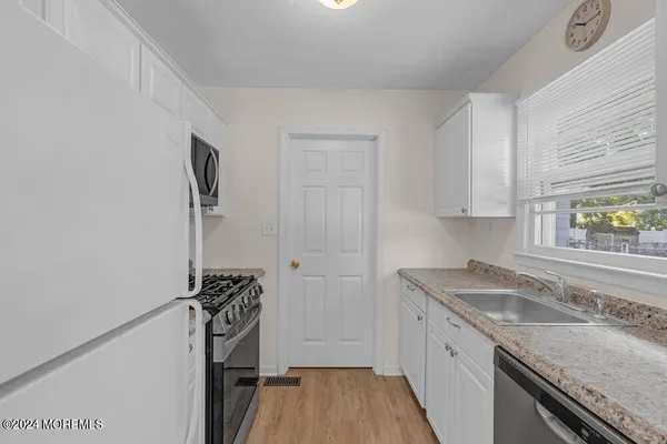a kitchen that has a sink a stove and a window