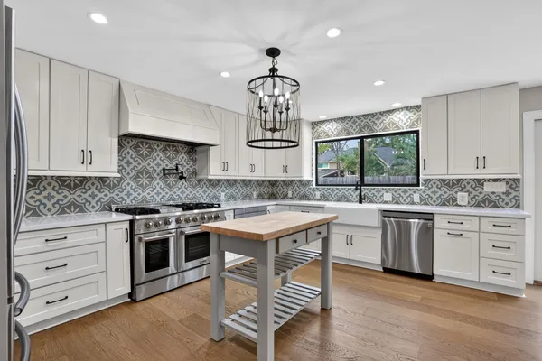 a kitchen with a stove cabinets and chandelier