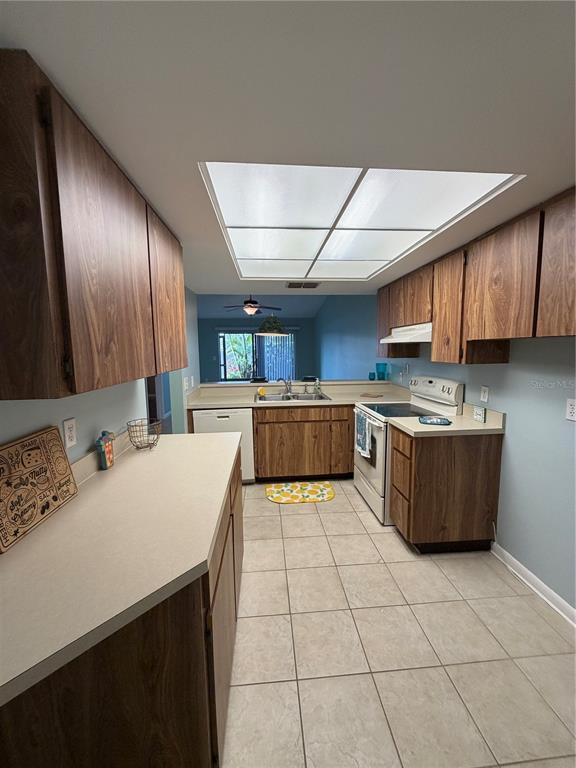 2131 Ridge Road South, Unit 135 Largo, FL 33778 - Photo 15 of 33 a large kitchen with a large counter top space a sink stainless steel appliances and cabinets