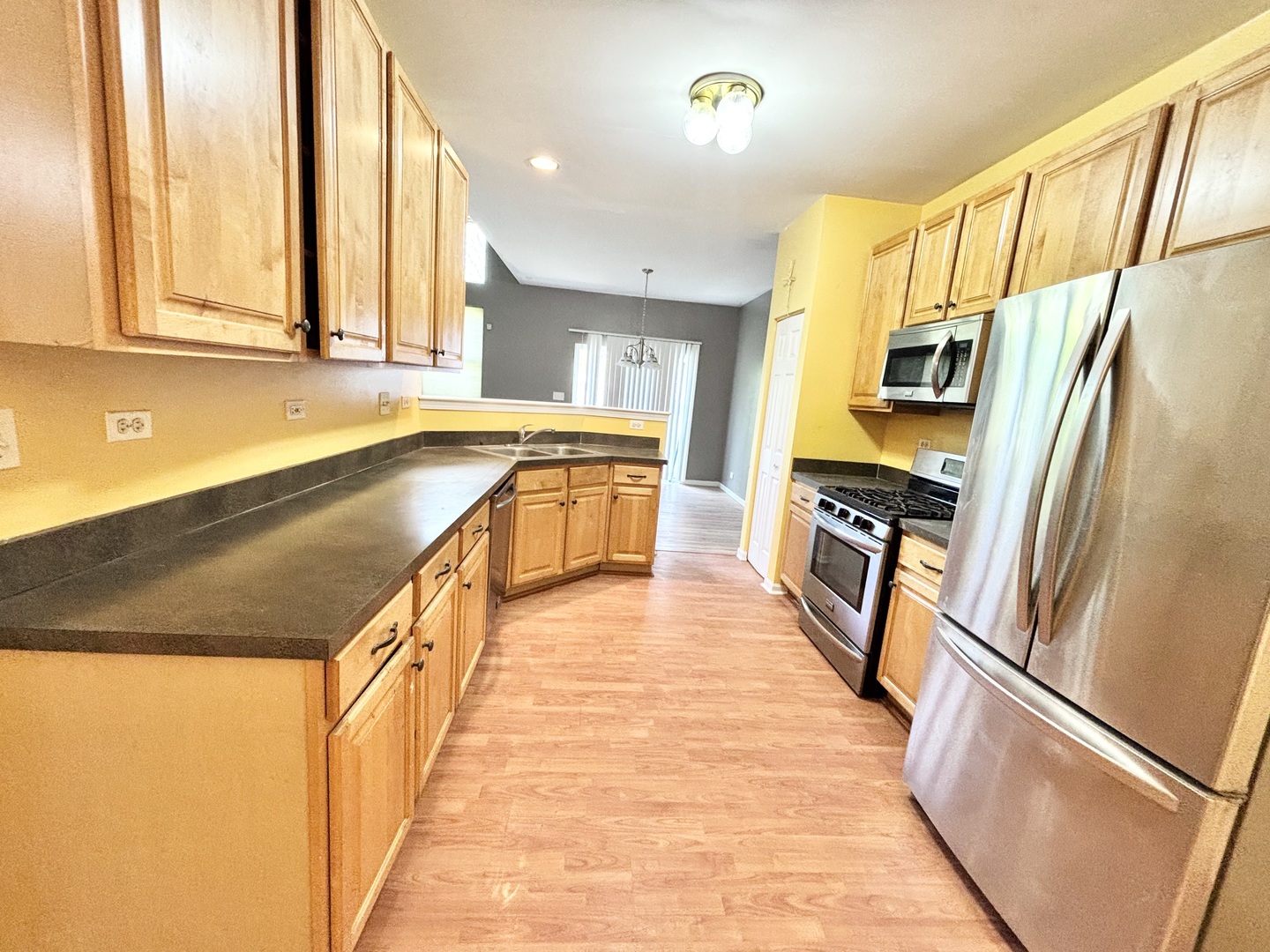 2428 Reflections Drive Aurora, IL 60502 - Photo 8 of 15 a kitchen with stainless steel appliances granite countertop a refrigerator a sink dishwasher and a stove with wooden floor