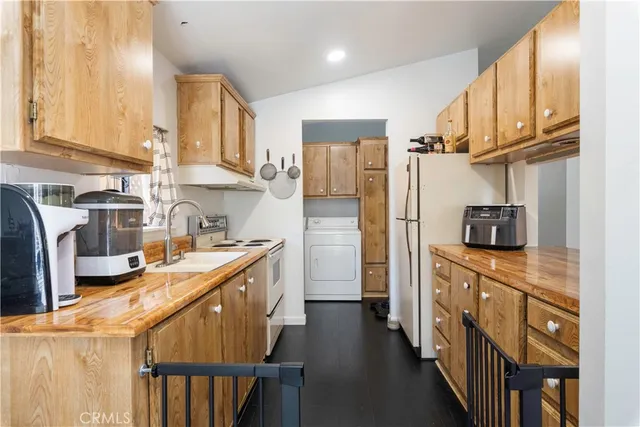 a kitchen with stainless steel appliances granite countertop a refrigerator a stove top oven a sink and dishwasher
