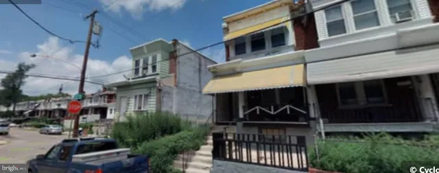 a view of a house with a small yard and potted plants