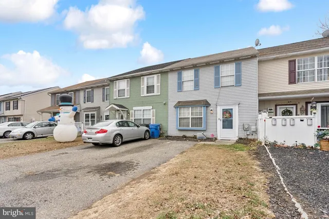 a front view of a house with cars parked