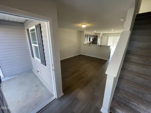 a view of a hallway with wooden floor and staircase
