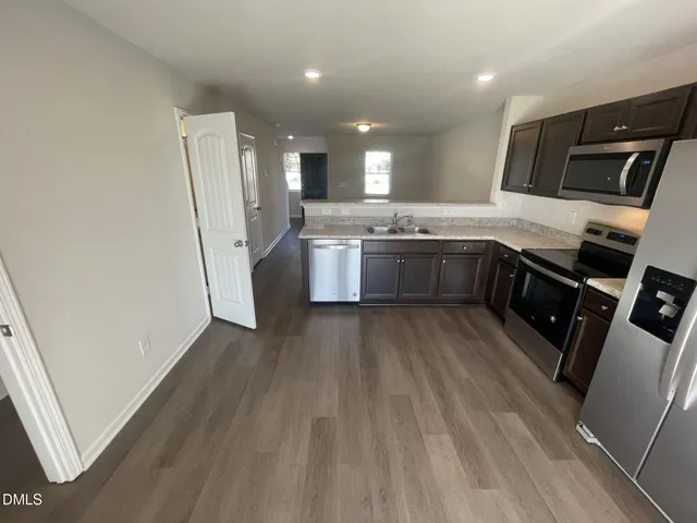 a large kitchen with a sink and refrigerator