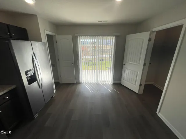 an empty room with wooden floor and a large window