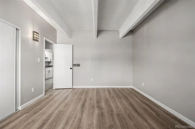 a view of a room with wooden floor and a window