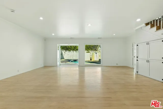 a view of empty room with wooden floor and fireplace