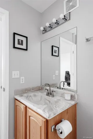 a bathroom with a granite countertop sink and a mirror