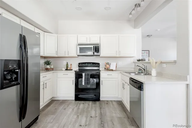 a kitchen with white cabinets and stainless steel appliances