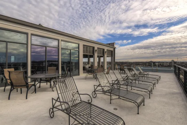 a view of a patio with chairs and floor to ceiling window