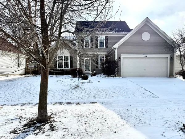 a front view of a house with a yard covered in snow