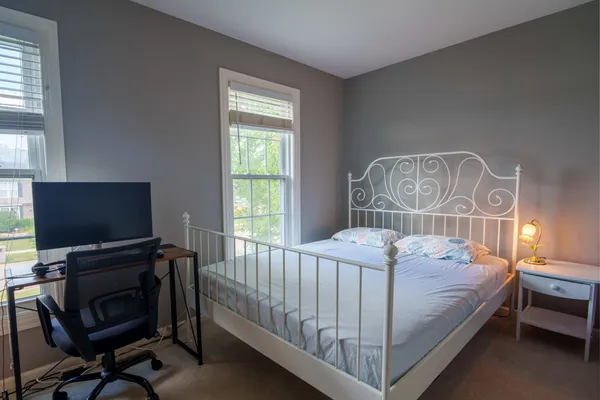 a bed sitting in a bedroom next to a window
