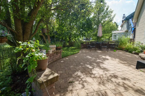 a view of a backyard with chairs and potted plants
