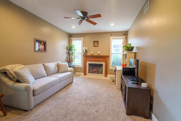 a living room with furniture a fireplace and a flat screen tv