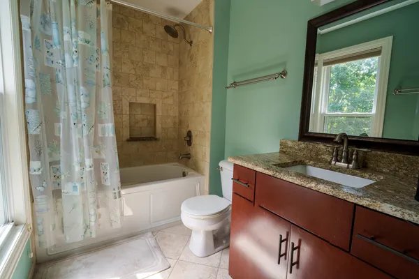 a bathroom with a granite countertop sink toilet and shower
