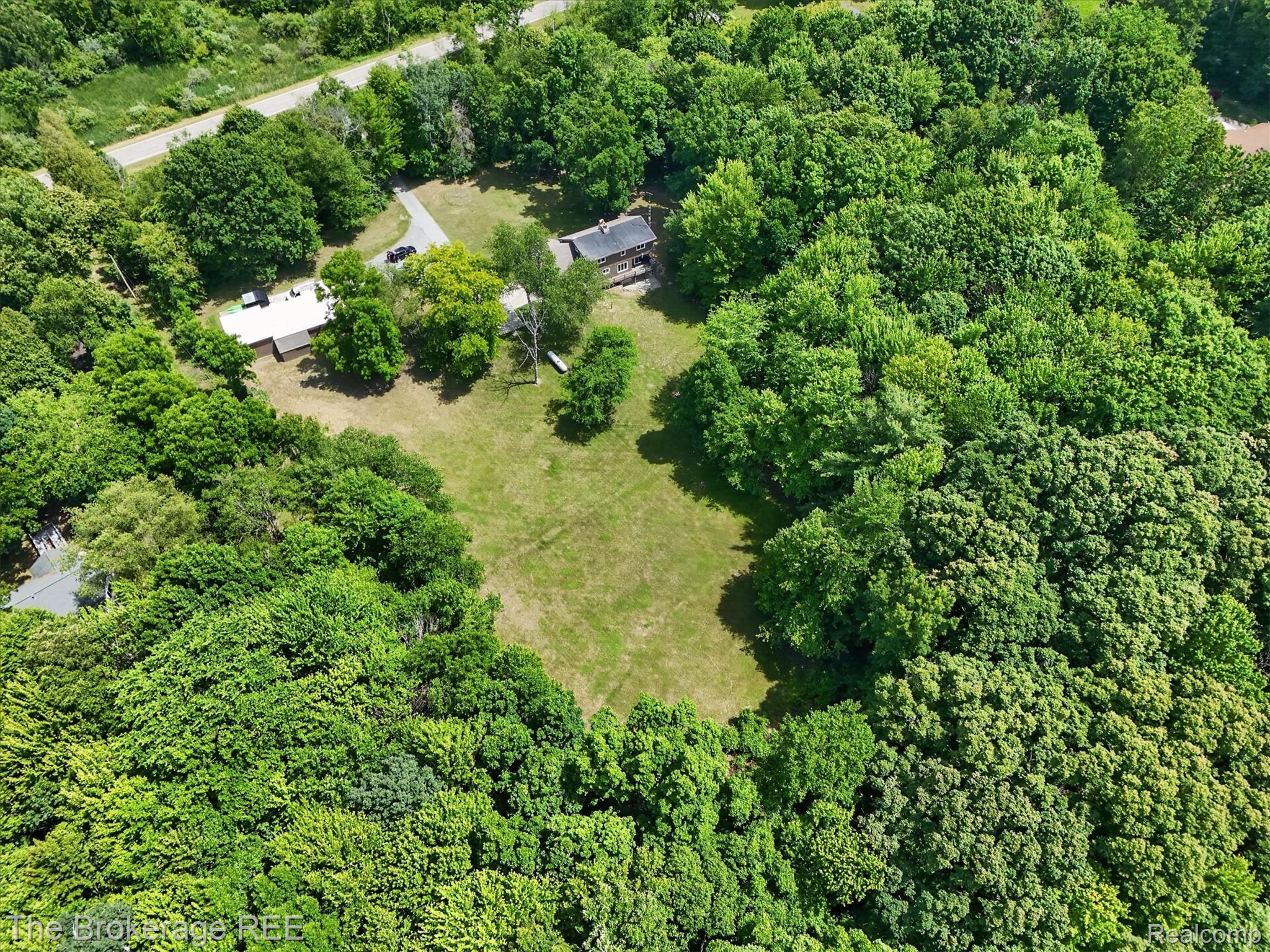 13269 North Genesee Road Clio, MI 48420 - Photo 63 of 67 Expansive property featuring a mix of mature trees, open grassy areas, and two distinct structures