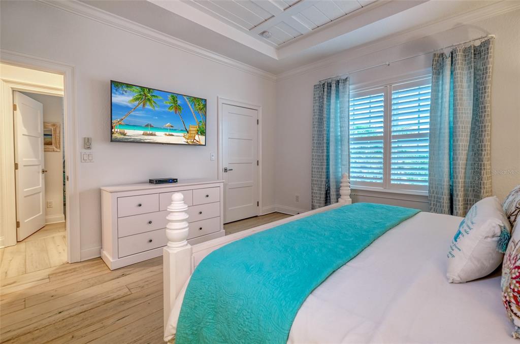 13511 Gulf Boulevard Madeira Beach, FL 33708 - Photo 11 of 30 a bedroom with a bed and a flat screen tv