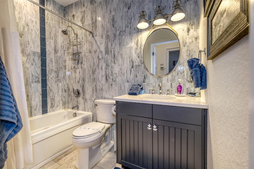 13511 Gulf Boulevard Madeira Beach, FL 33708 - Photo 16 of 30 a bathroom with a sink vanity mirror and toilet