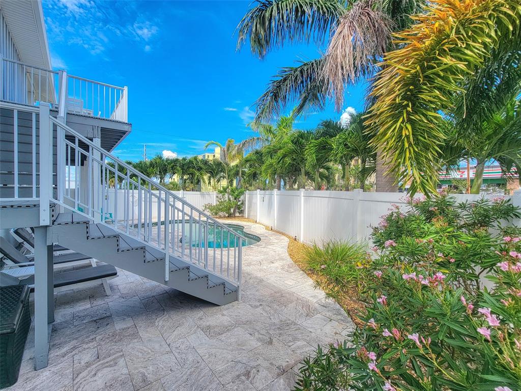 13511 Gulf Boulevard Madeira Beach, FL 33708 - Photo 22 of 30 a view of a yard with plants and wooden fence