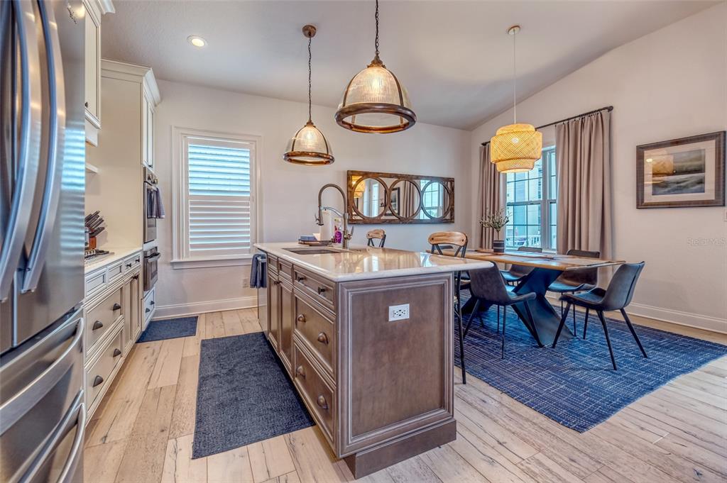 13511 Gulf Boulevard Madeira Beach, FL 33708 - Photo 3 of 30 a kitchen with a stove a sink a dining table and chairs