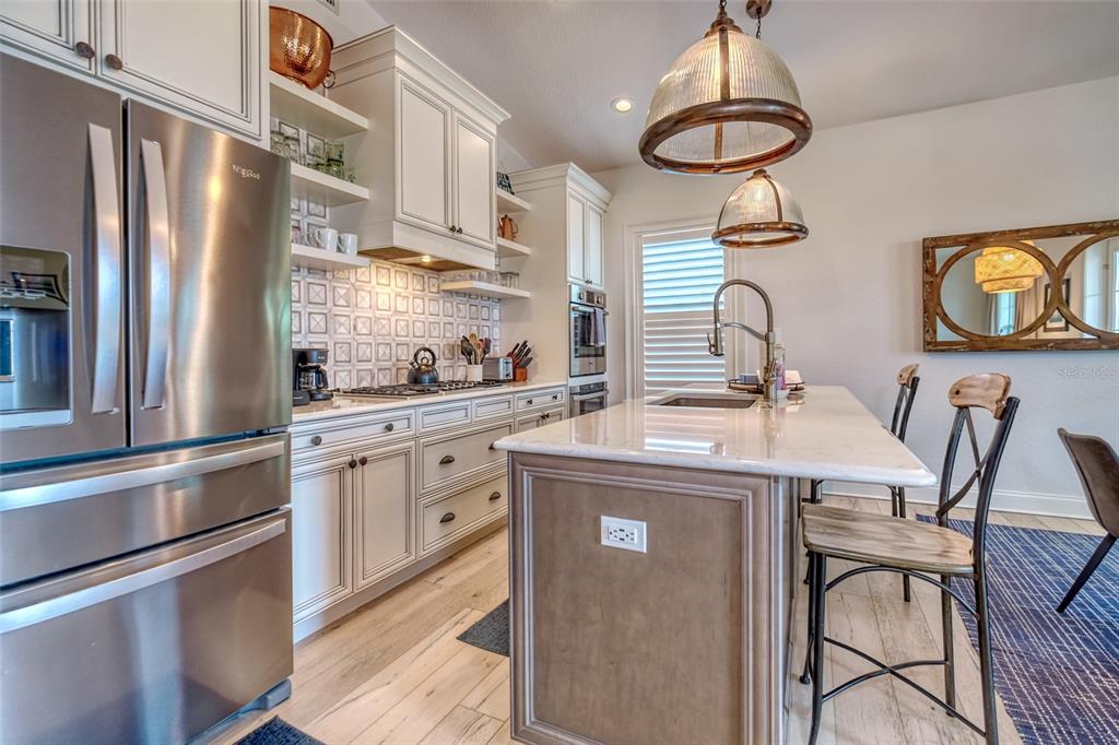 13511 Gulf Boulevard Madeira Beach, FL 33708 - Photo 4 of 30 a kitchen with stainless steel appliances granite countertop a sink a stove and refrigerator