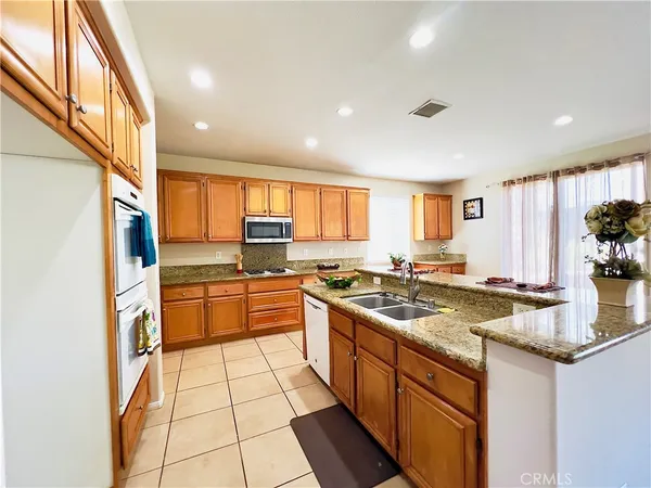 a kitchen with stainless steel appliances granite countertop a stove a sink and a refrigerator