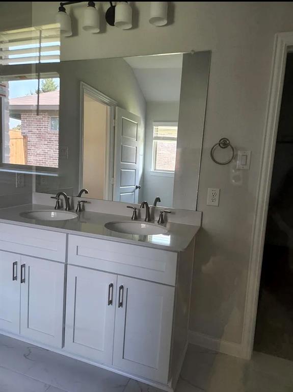 2043 Atlantic Avenue Anna, TX 75409 - Photo 15 of 25 a bathroom with a granite countertop sink a mirror a vanity and a window
