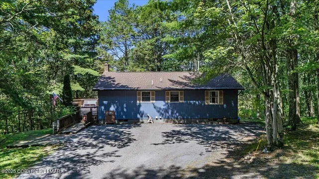 a view of a house with a yard and large tree