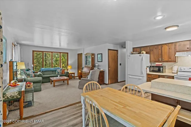 a living room with furniture a large window and wooden floor