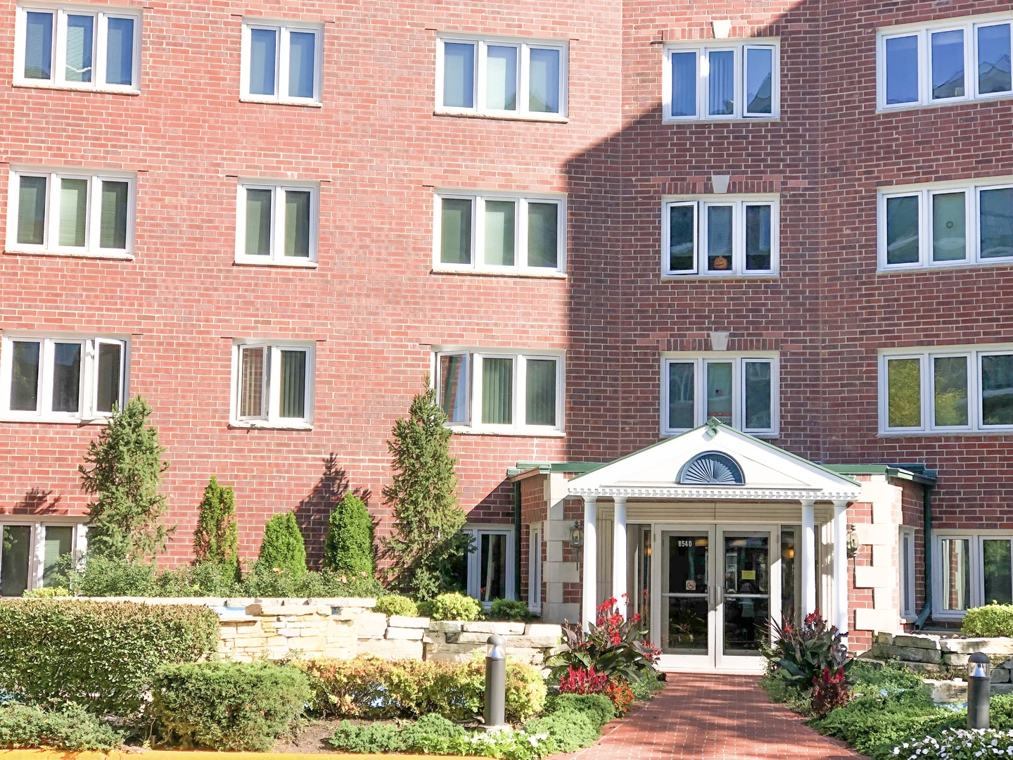 a front view of a brick house with a yard