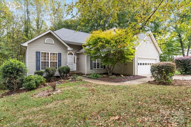 a view of a house with a yard and large tree