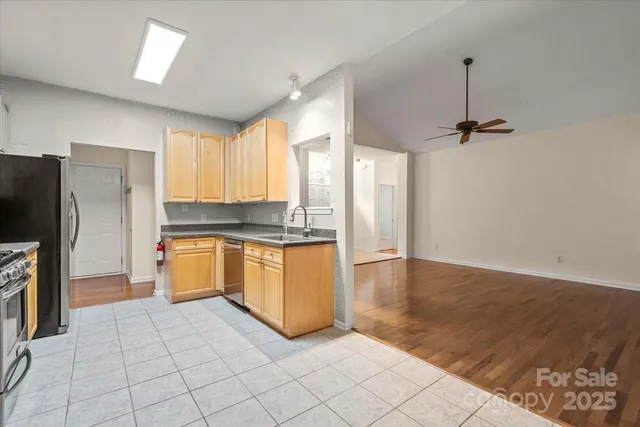a large kitchen with a large window and stainless steel appliances