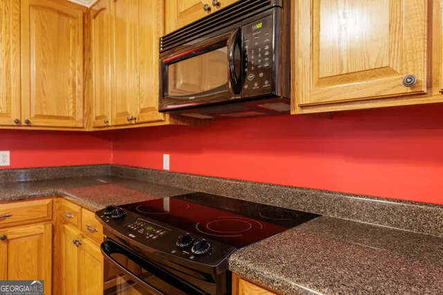 a kitchen with stainless steel appliances granite countertop a stove top oven and cabinets