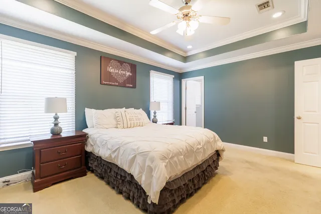 a bedroom with a large bed and a chandelier