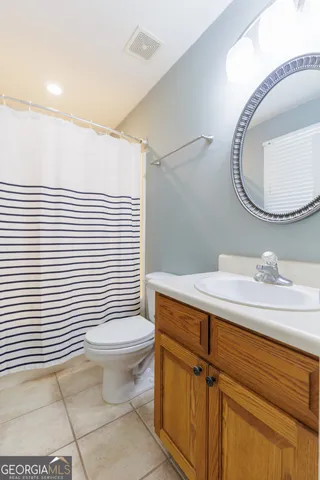 a bathroom with a sink a toilet and mirror