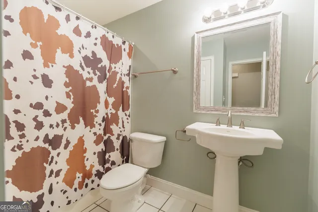a bathroom with a sink and mirror with toilet