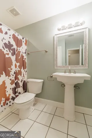 a bathroom with a sink toilet and mirror