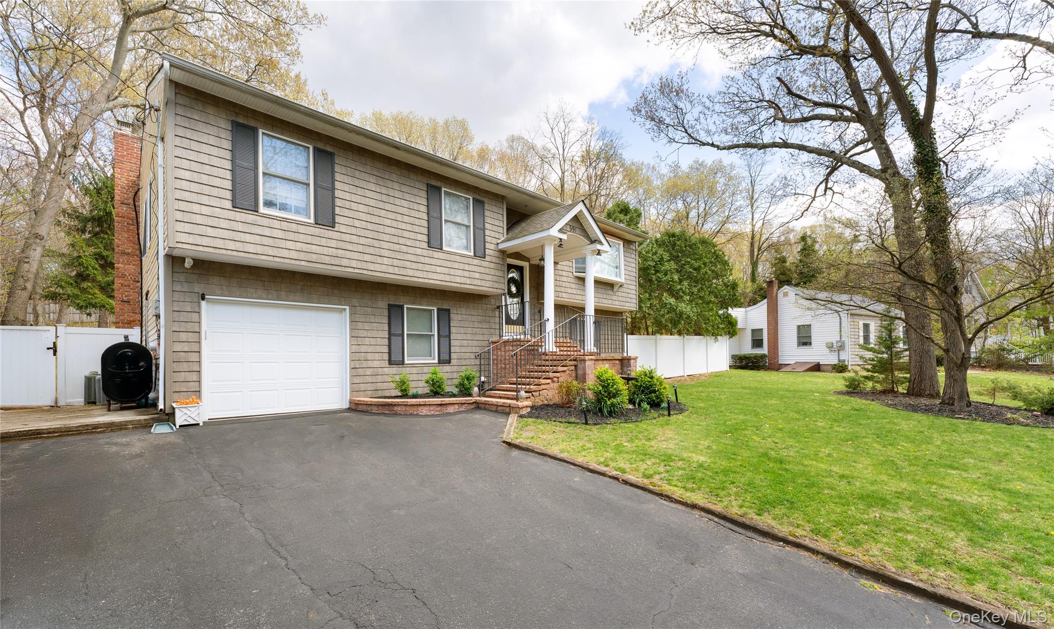 591 Meadow Road Kings Park, NY 11754 - Photo 2 of 50 a view of a house with a large window and a large tree