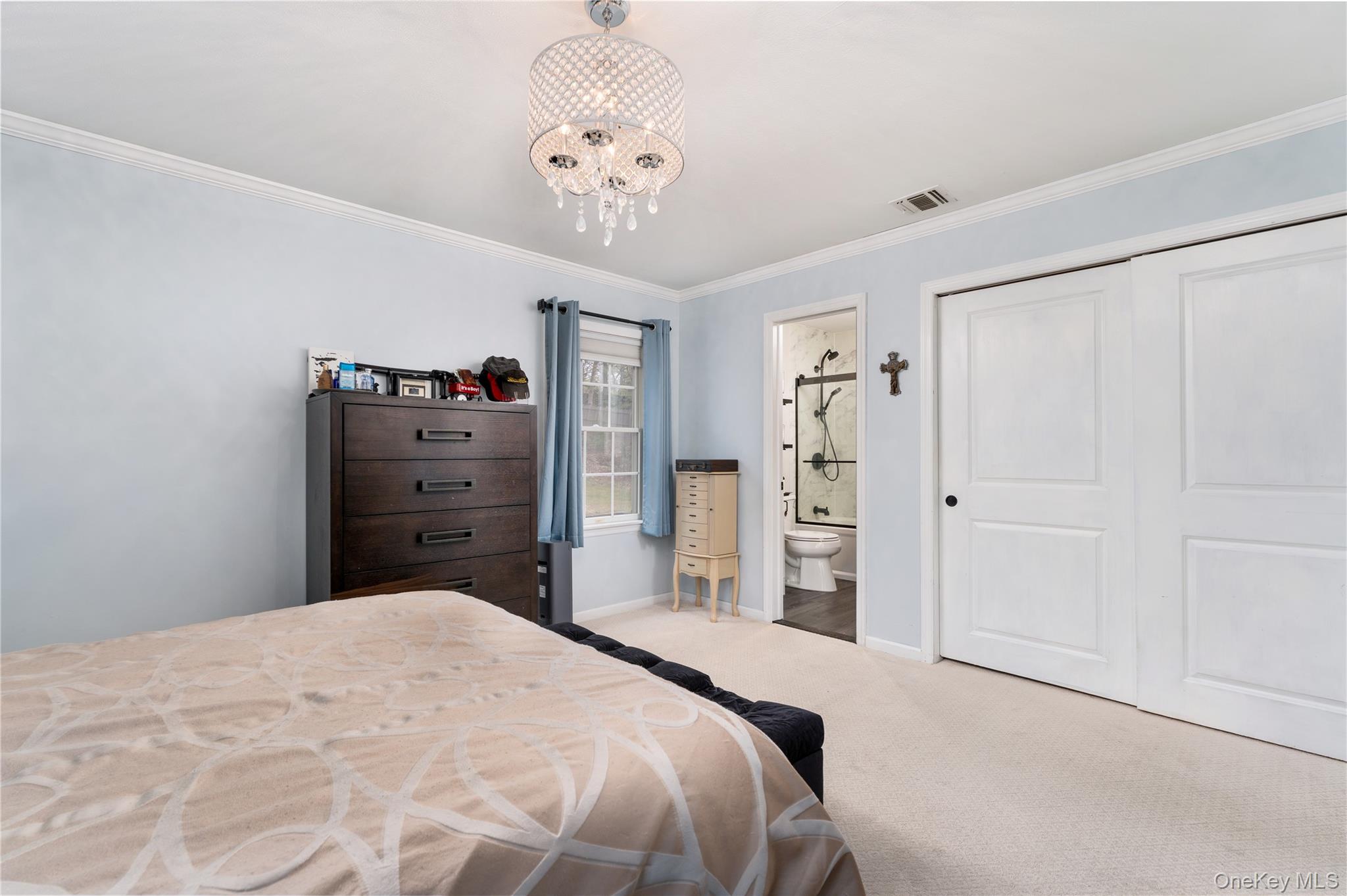 591 Meadow Road Kings Park, NY 11754 - Photo 31 of 50 a bedroom with a bed and a chandelier