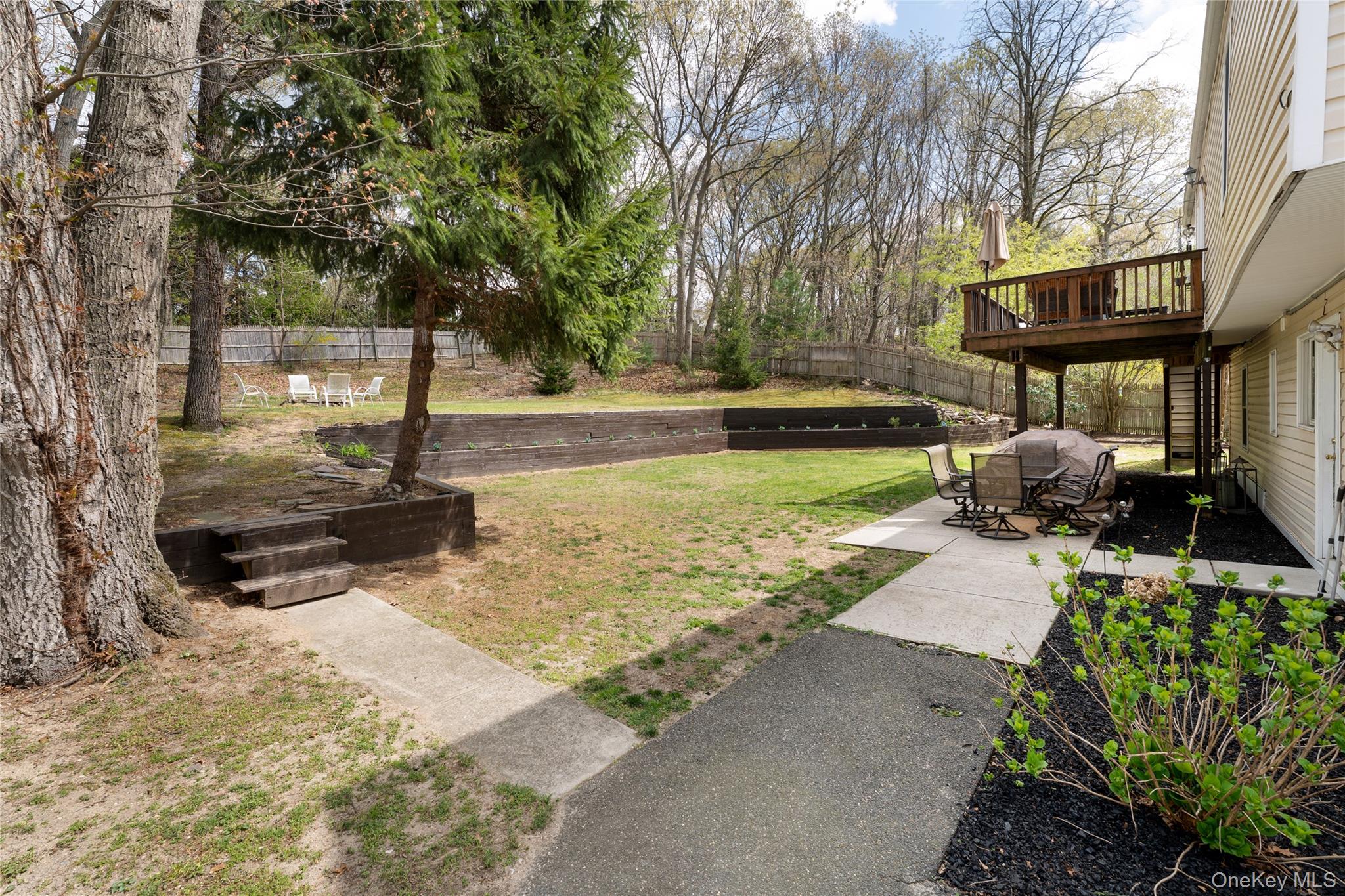 591 Meadow Road Kings Park, NY 11754 - Photo 7 of 50 a view of a yard with plants and a bench