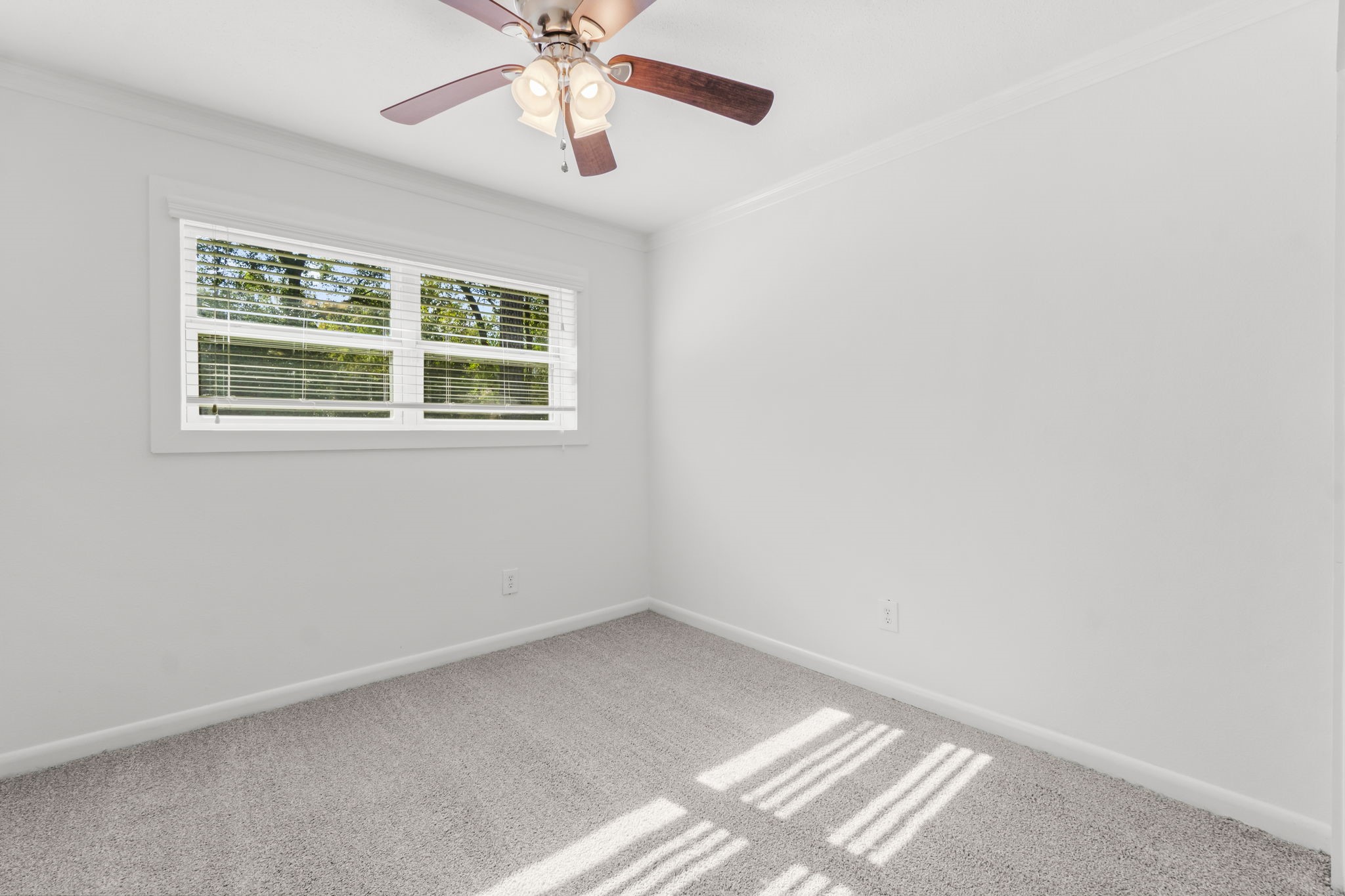 3223 Kentwood Drive Spring, TX 77380 - Photo 22 of 31 Secondary bedroom with bright windows, ceiling fan, and soft carpeting.
