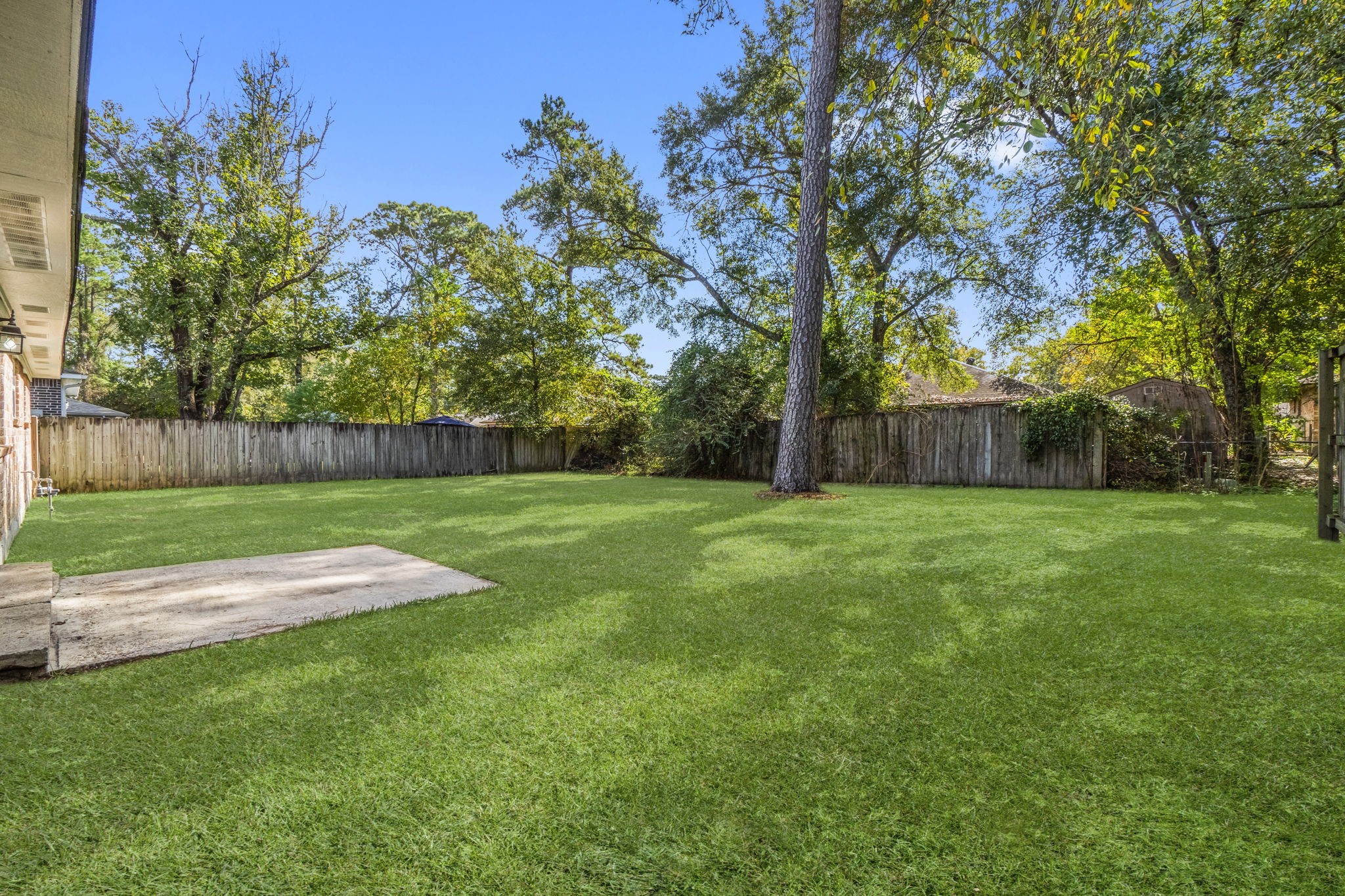 3223 Kentwood Drive Spring, TX 77380 - Photo 27 of 31 Concrete patio slab overlooking the yard - ideal for grilling, outdoor dining, or relaxing. The patio offers a great transition from indoor living to the wide-open outdoor space.